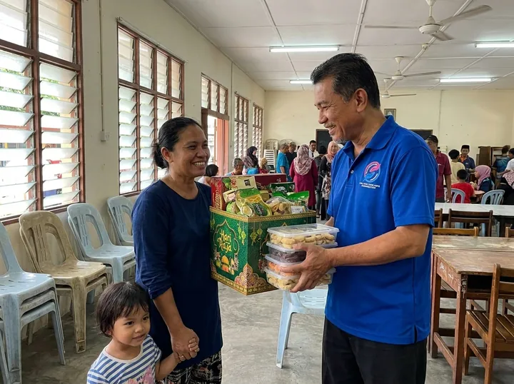 Penyerahan hamper perayaan kepada keluarga.