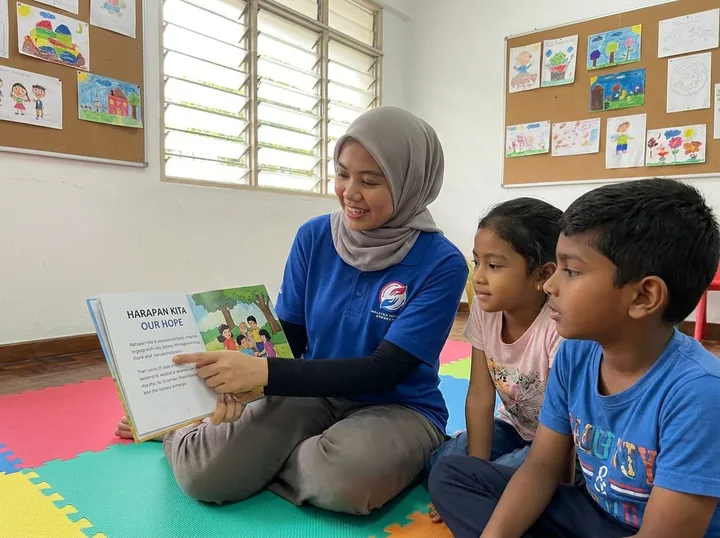 A volunteer reads with children.